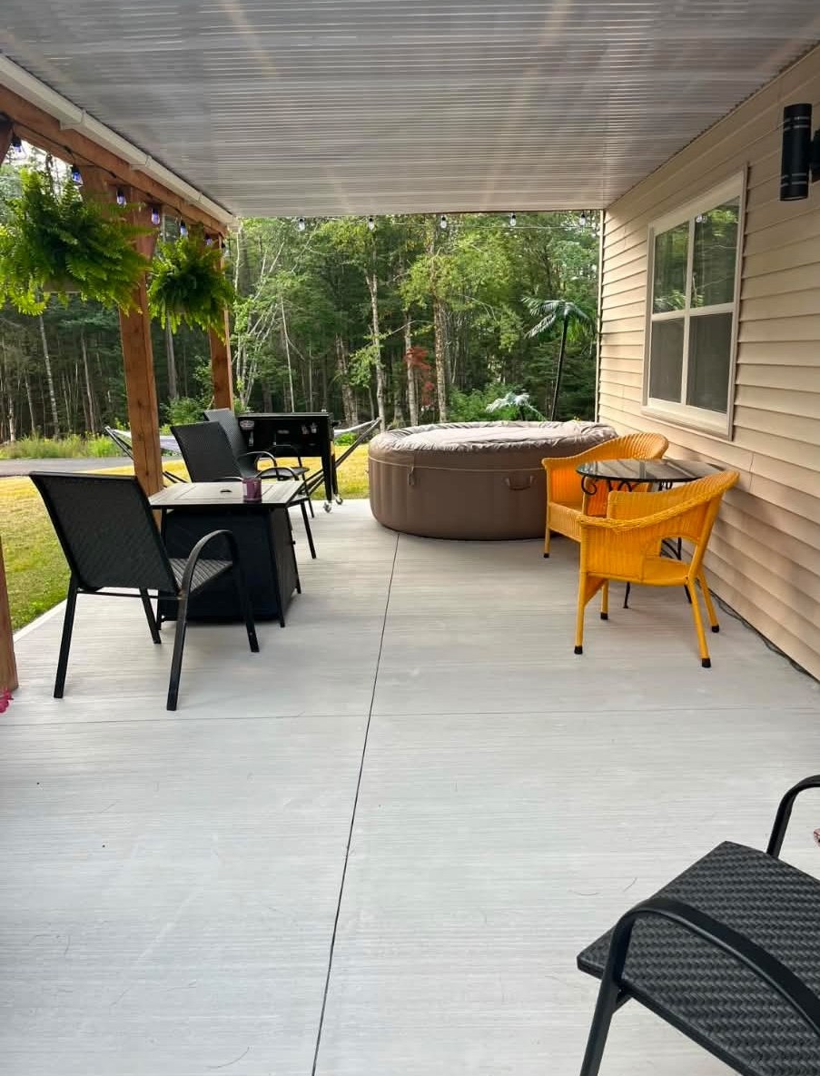 Light grey epoxy patio with hot tub and outdoor furniture